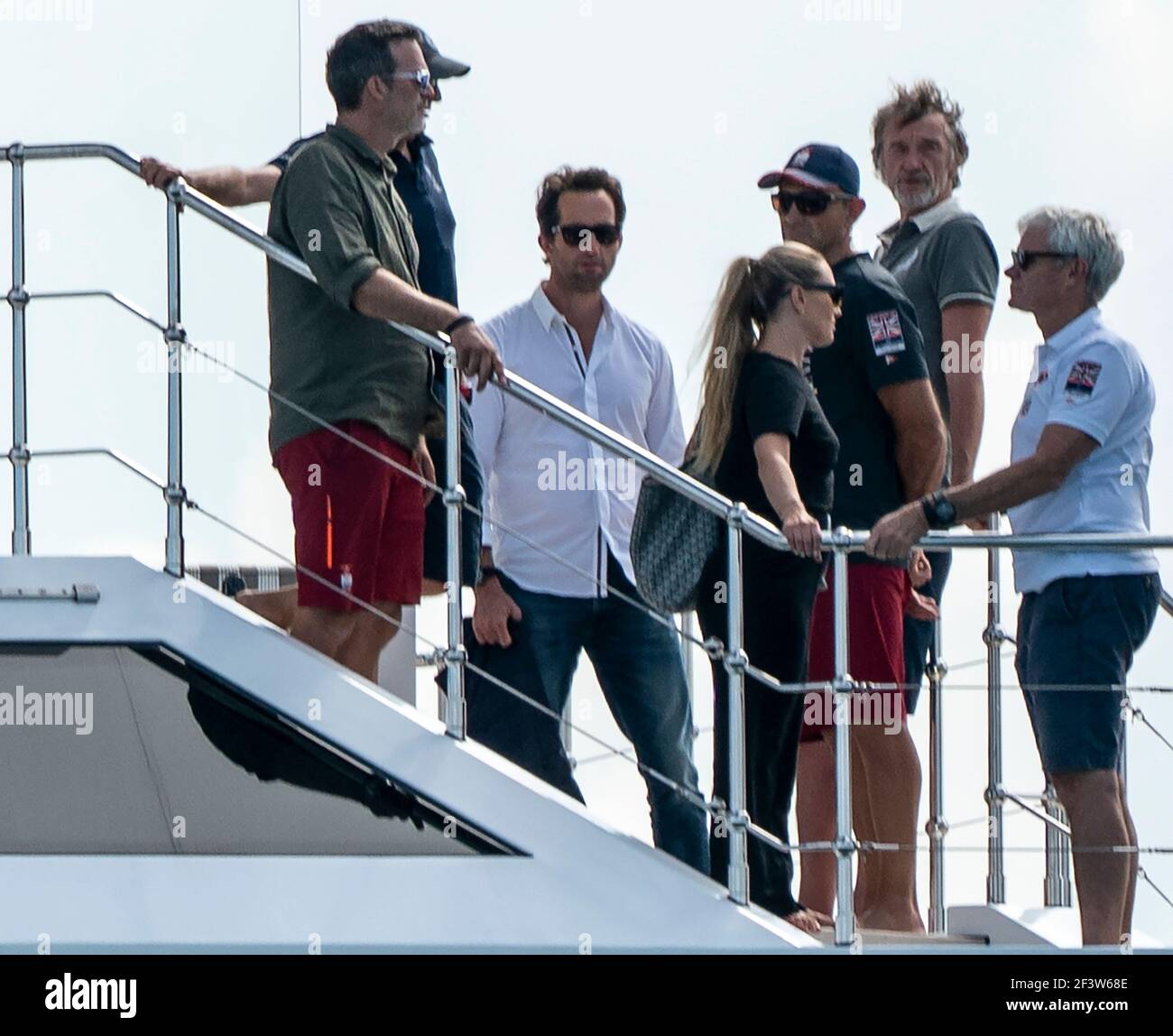 Auckland, New Zealand, 17 March, 2021 -  Owner of Ineos Team UK sailing team British billionaire Sir Jim Ratcliffe (2nd from right) prepares to view the final race of the 36th America's Cup on Auckland's Waitemata Harbour from his $100,000,000 super yacht Sherpa. Pictured with him are Ineos Team UK's founder and skipper Sir Ben Ainslie (white shirt)i with his wife Lady Ainslie (Georgie Thompson) and other guests. Following  Team New Zealand's (ETNZ) 7-3 victory over Italian challenger  Luna Rossa, Ineos Team UK are now believed to be the America's Cup Challenger of Record and will work with ET Stock Photo