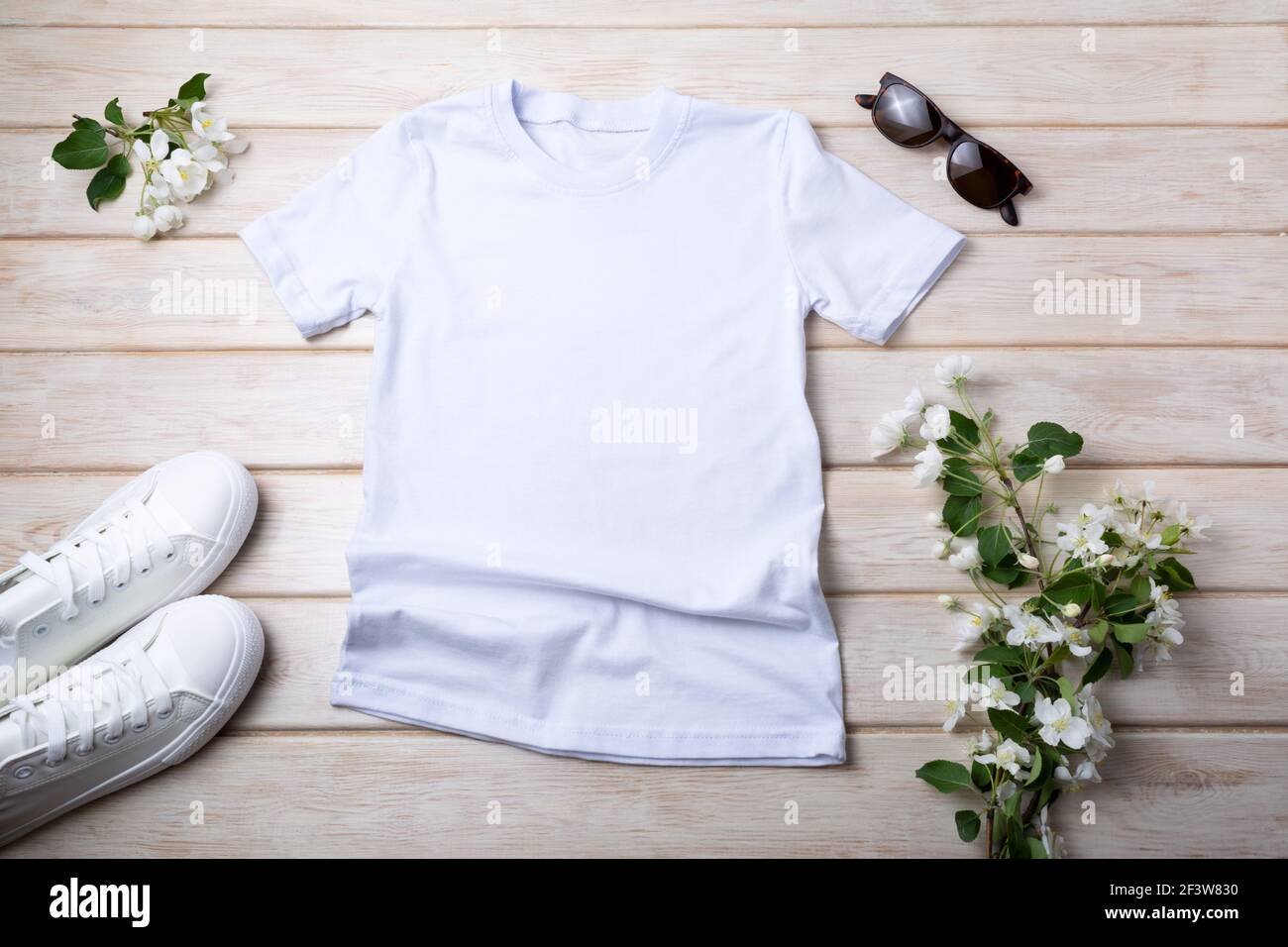 White womens cotton T-shirt mockup with sneakers, sunglasses and apple blossom. Design t shirt template, tee print presentation mock up Stock Photo