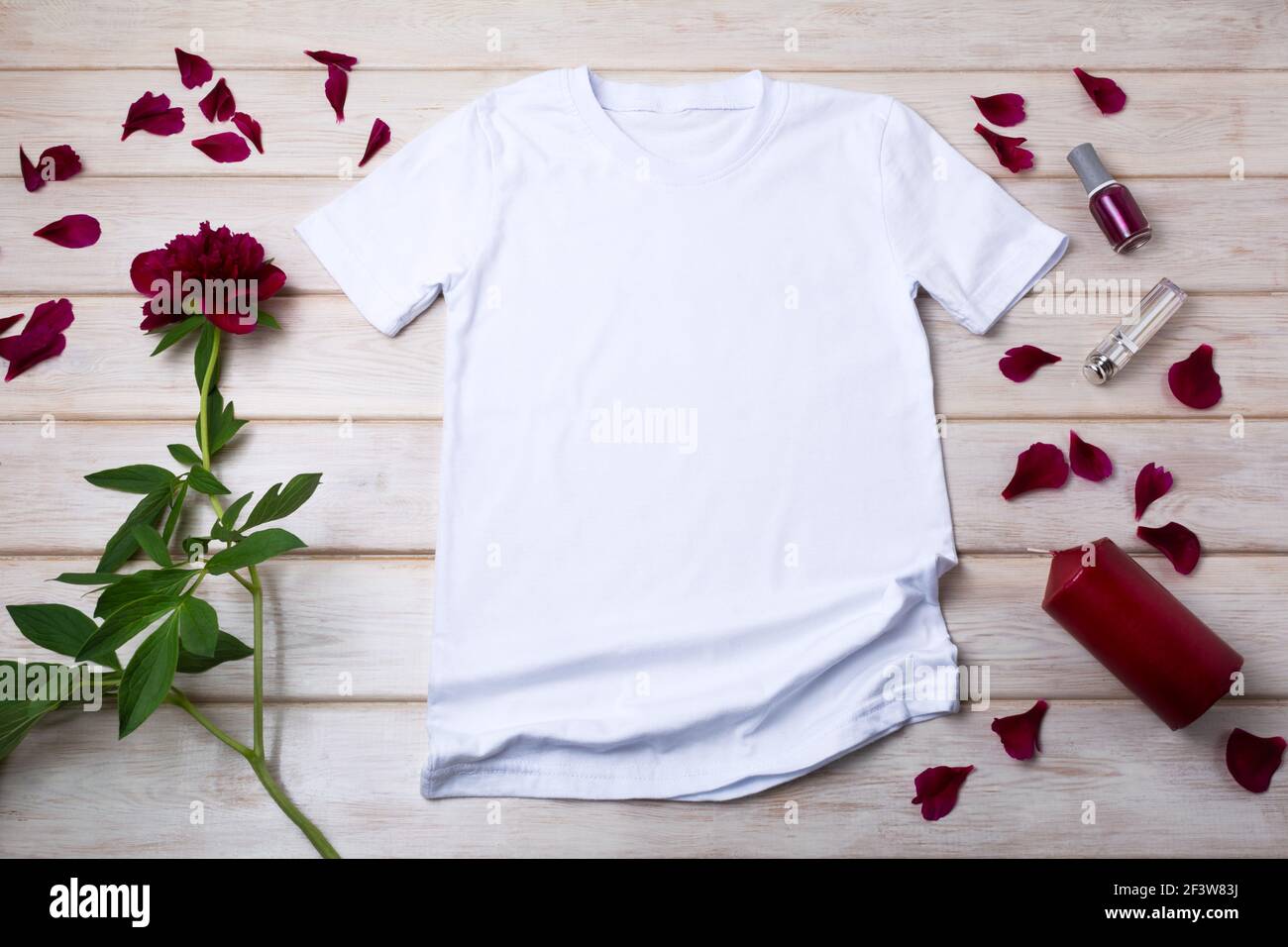 White women cotton T-shirt mockup with red candle and burgundy peony. Design t shirt template, tee print presentation mock up Stock Photo