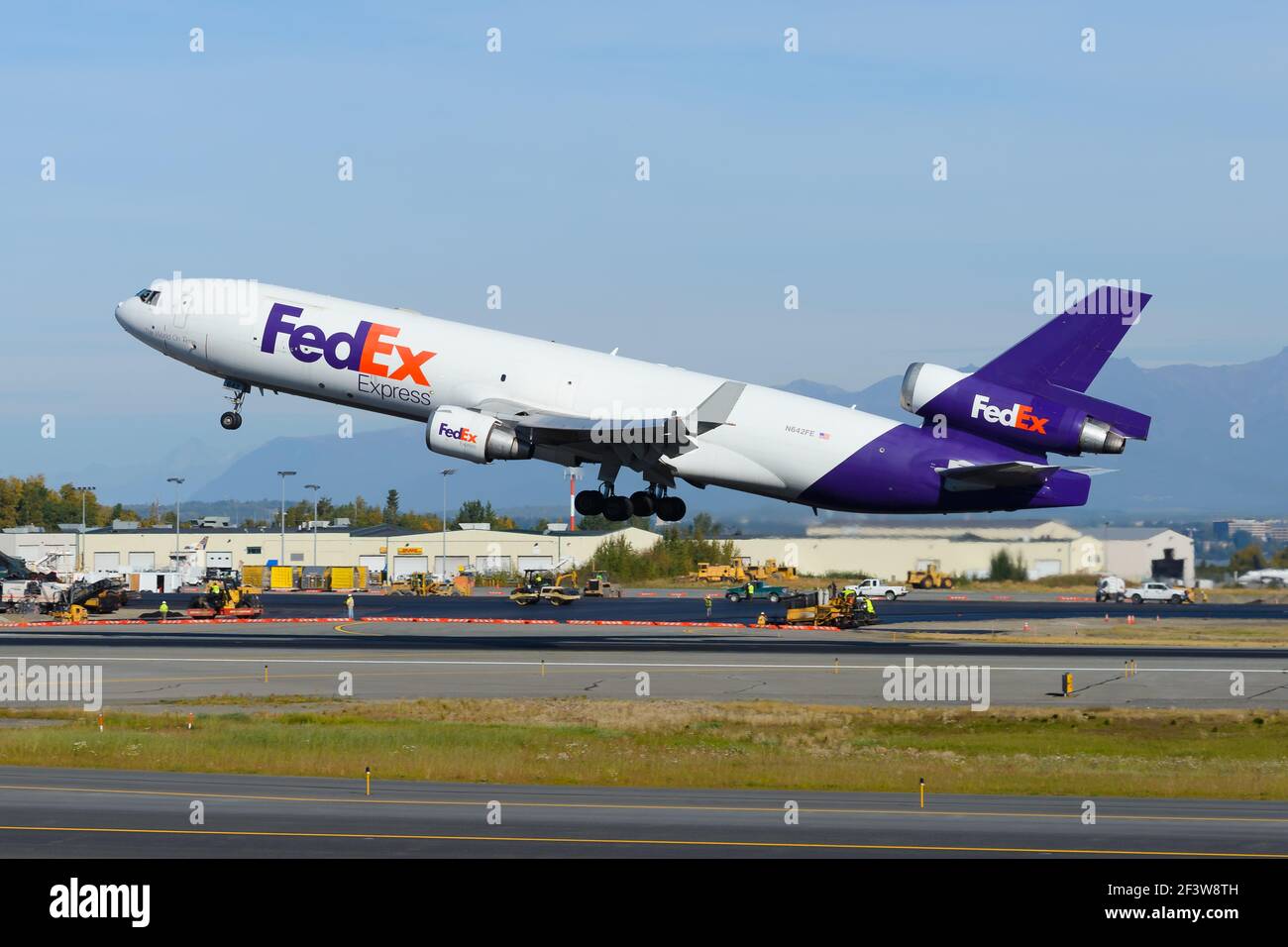 FedEx cargo aircraft McDonnell Douglas MD-11F taking off from Anchorage Airport. Federal Express freighter airplane MD11. Plane departing. Stock Photo