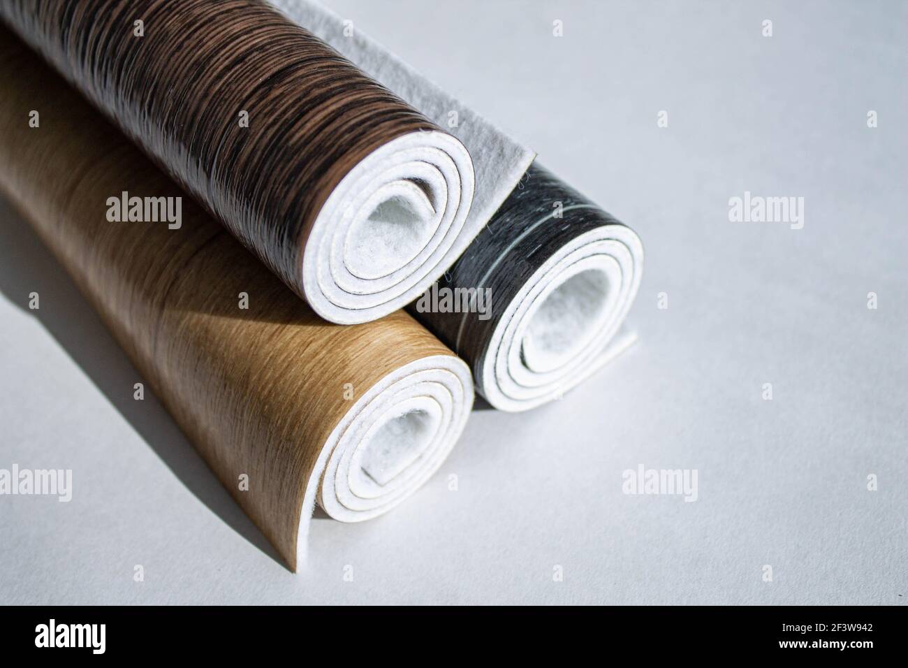 Linoleum. Three rolls of linoleum on a white background. Floor coverings for home use. Linoleum