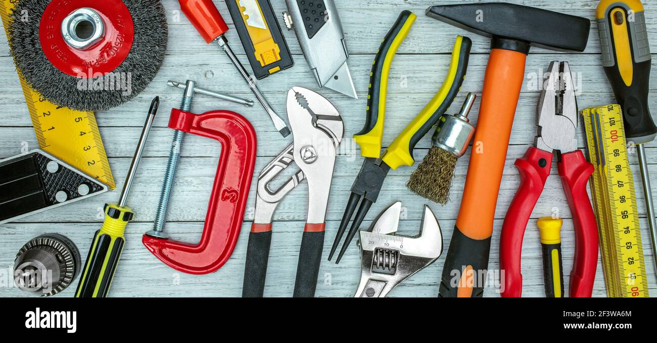 various working tools on grey table background. drills, wrenches, bolts, screws, clamps top view Stock Photo