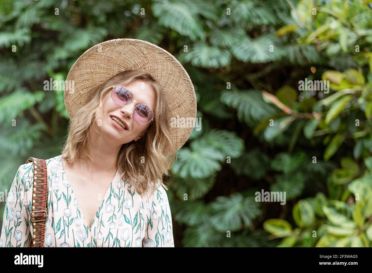 beautiful young blonde woman in a straw hat and glasses posing in the ...