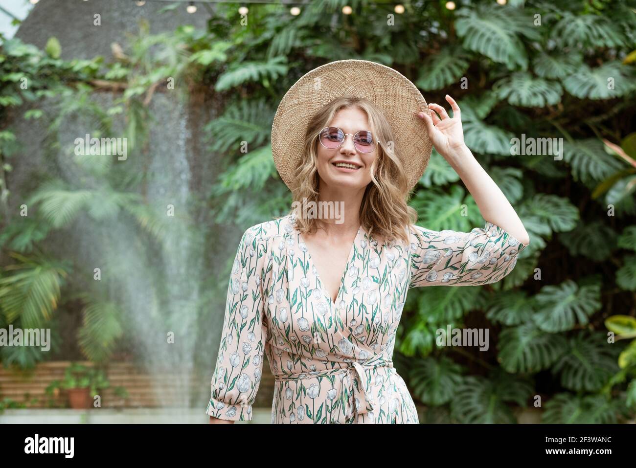 beautiful young blonde woman in a straw hat and glasses posing in the ...