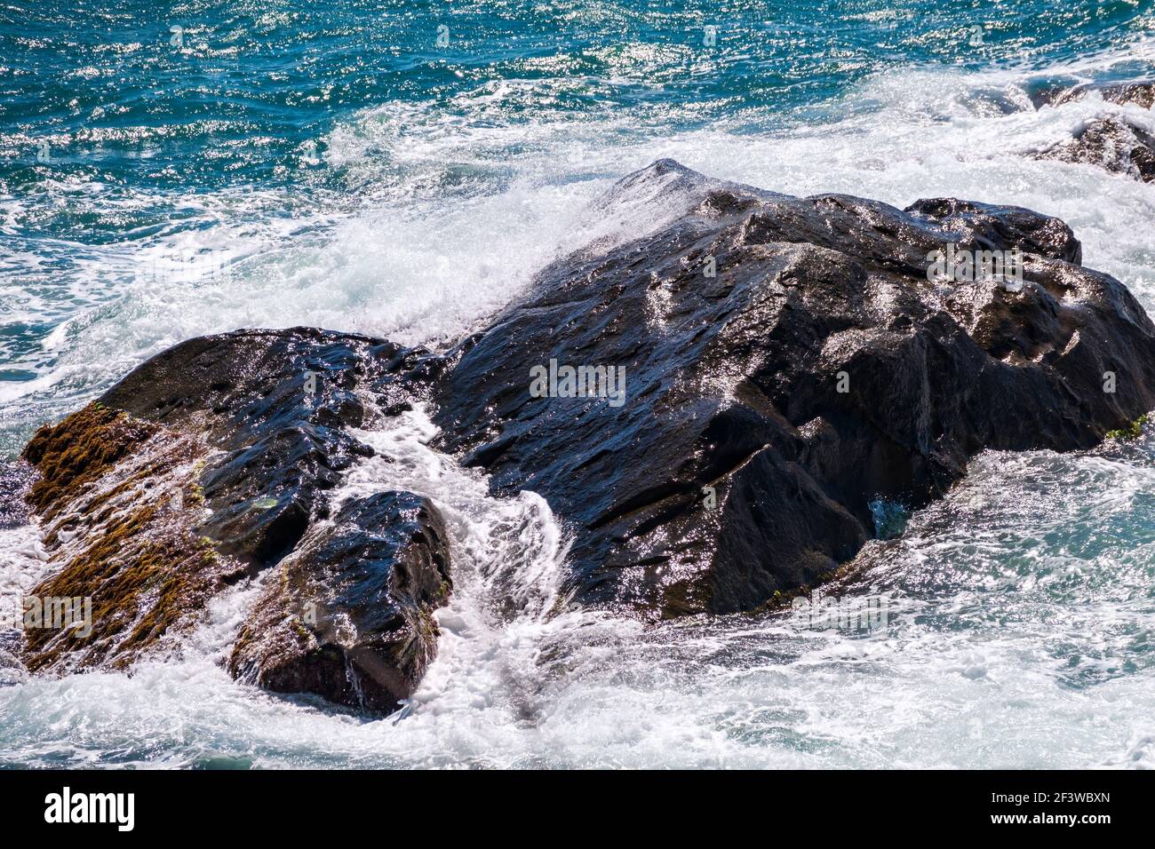 Sea water beats against rocks. Sea waves of dark water beat against the ...