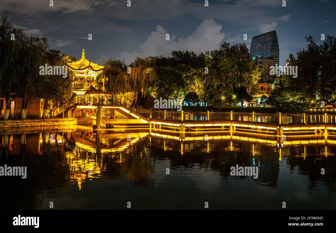 Green lake park scenic view at night with illuminated path and pavilion over a pond in Kunming Yunnan China Stock Photo