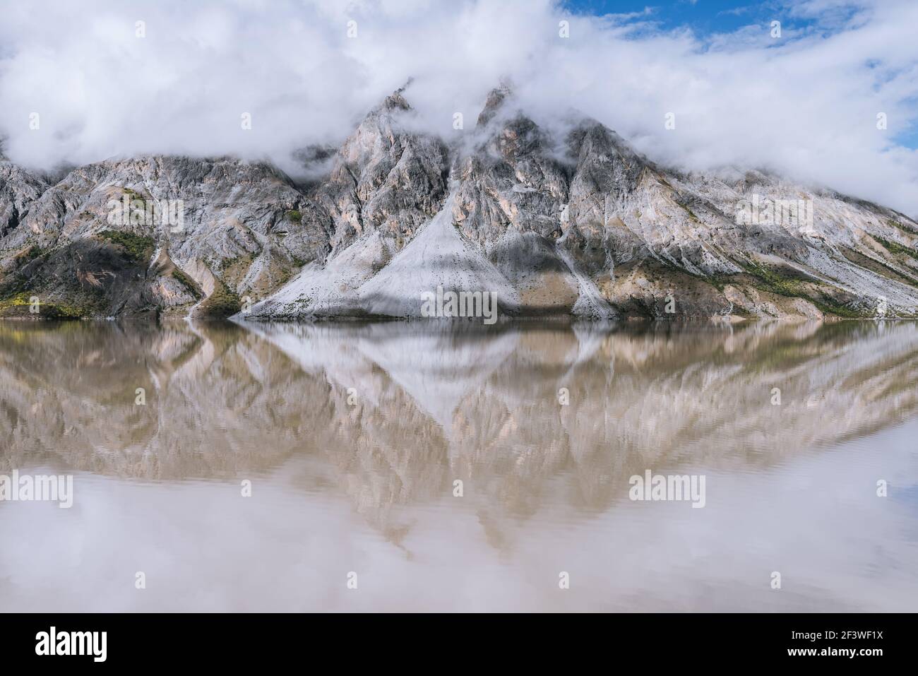 The calm surface of the lake and the reflection of the mountains by the lake Stock Photo