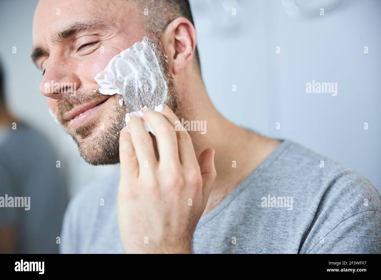 Handsome man applying shaving cream on face Stock Photo Alamy