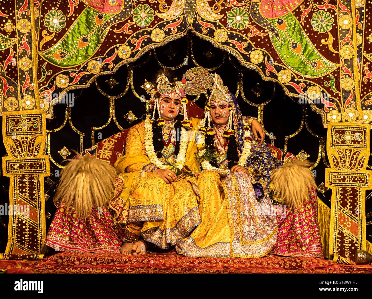 young actor representing krishna and radha marriage on stage with selective focus in subject and added noise and grains. Stock Photo