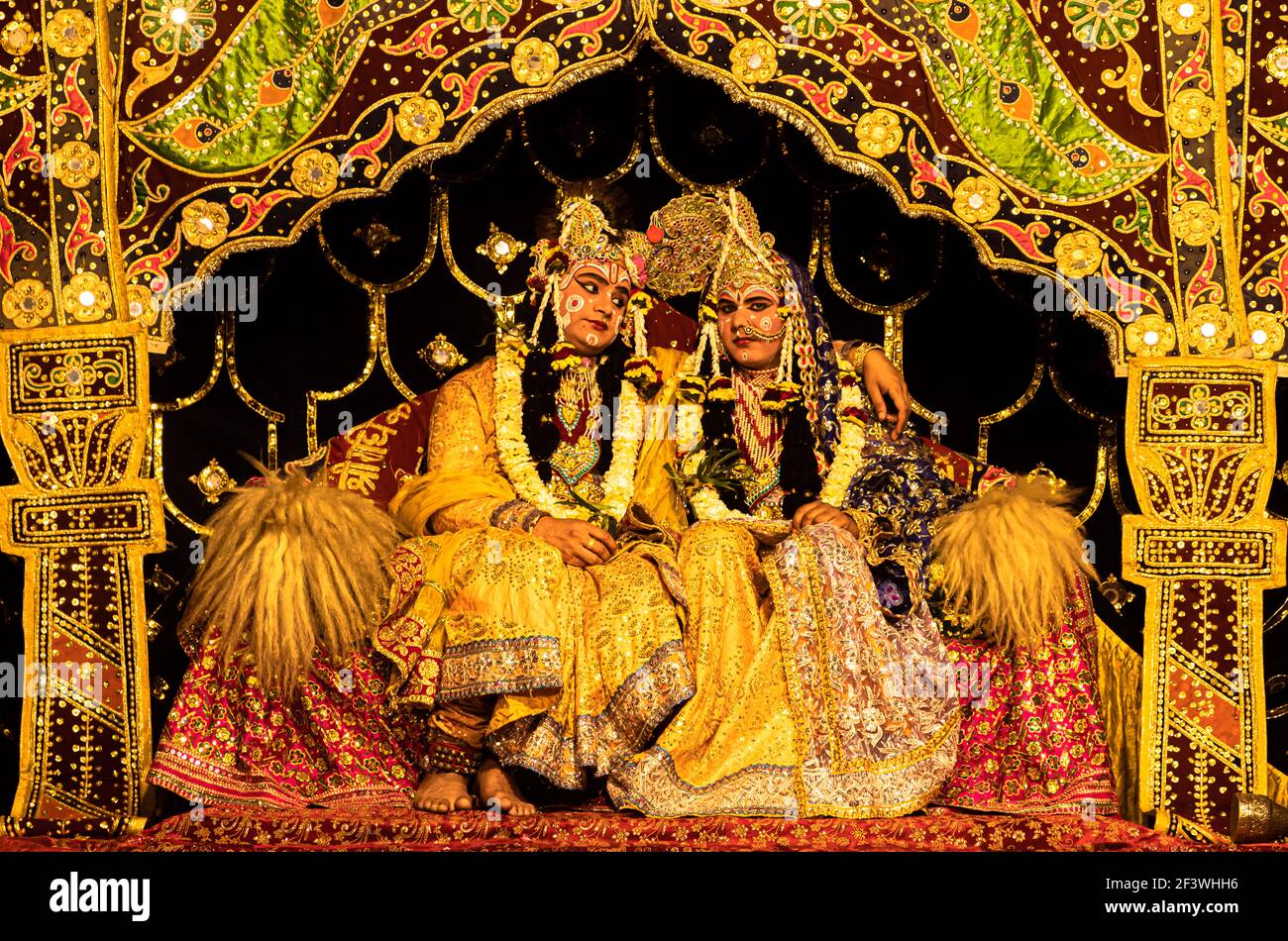 young actor representing krishna and radha marriage on stage with selective focus in subject and added noise and grains. Stock Photo