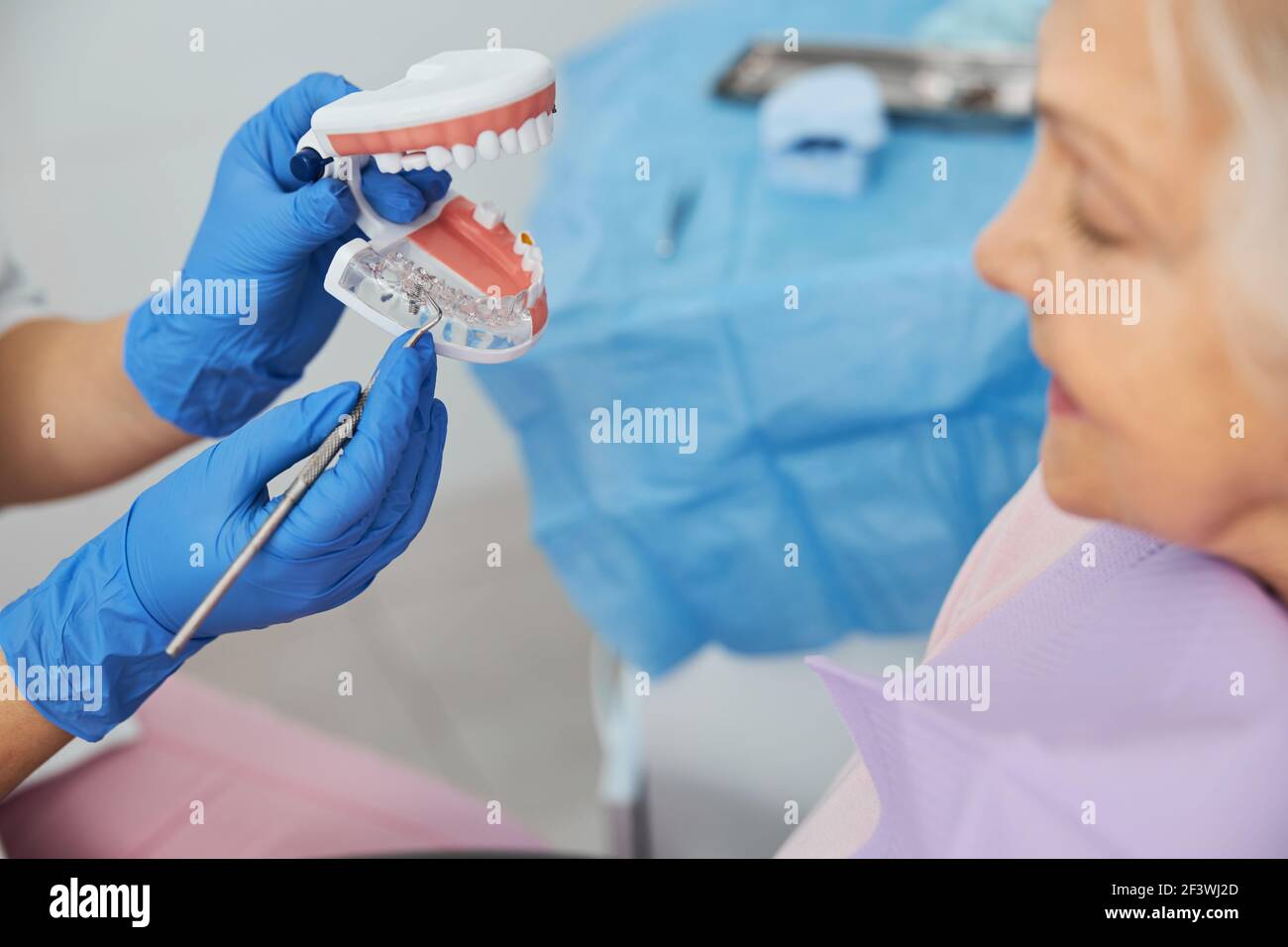 Dental explorer attracting attention to implant in teeth model Stock