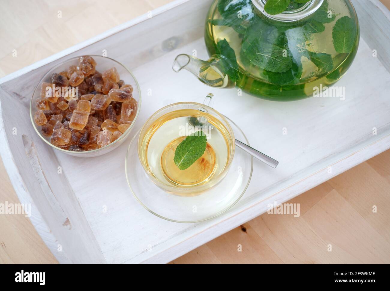 Fresh brewed mint tea on tray with teacup teapot and candi sugar ...