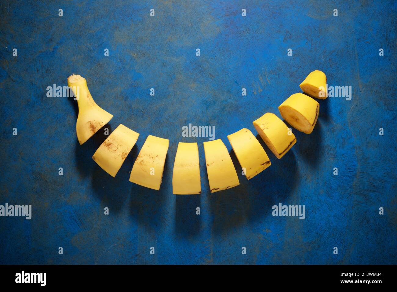 Canarian banana cut into pieces on a blue table. Stock Photo