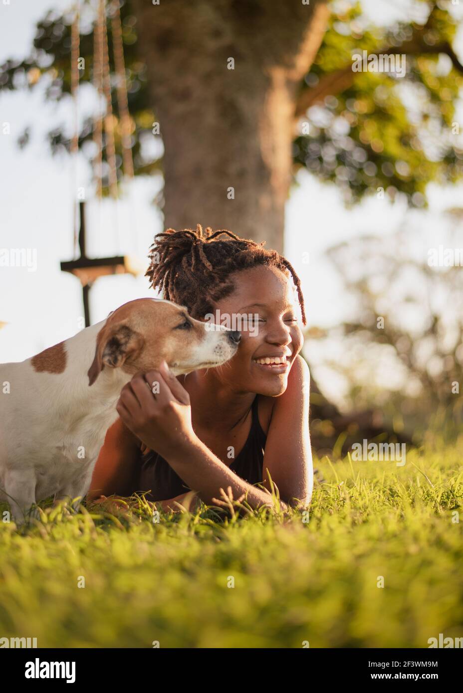 Young girl playing with a dog in the garden Stock Photo