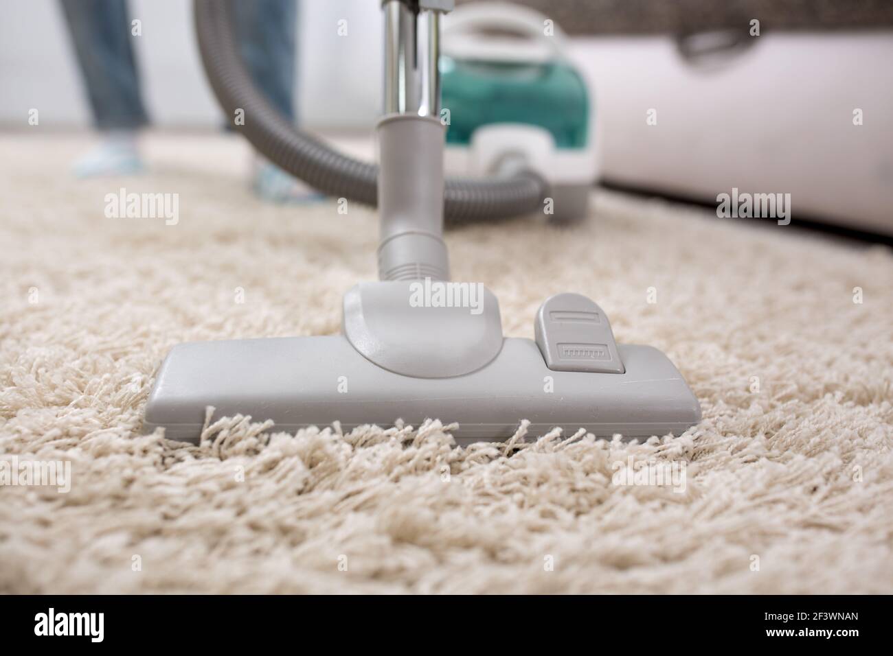Woman with vacuum cleaner cleaning carpet at home Stock Photo - Alamy