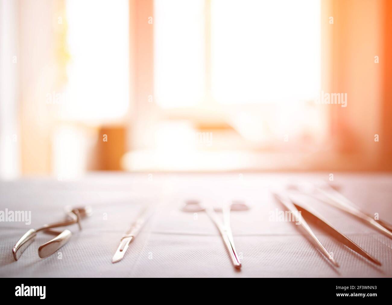 Surgical instruments on the table in the operating room of the hospital. Sunny sunset in the window. Surgery concept, amputation, complications after Stock Photo