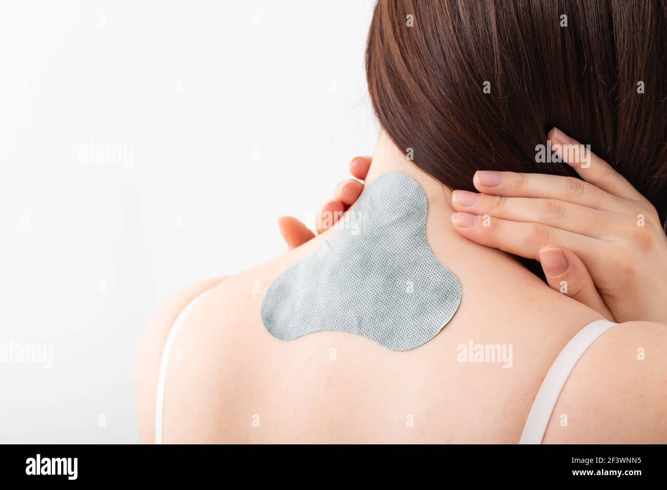 Medical plaster for relieving pain in the neck and spine. Anti-inflammatory with analgesic effect, elimination of muscle spasm in the girl's neck Stock Photo