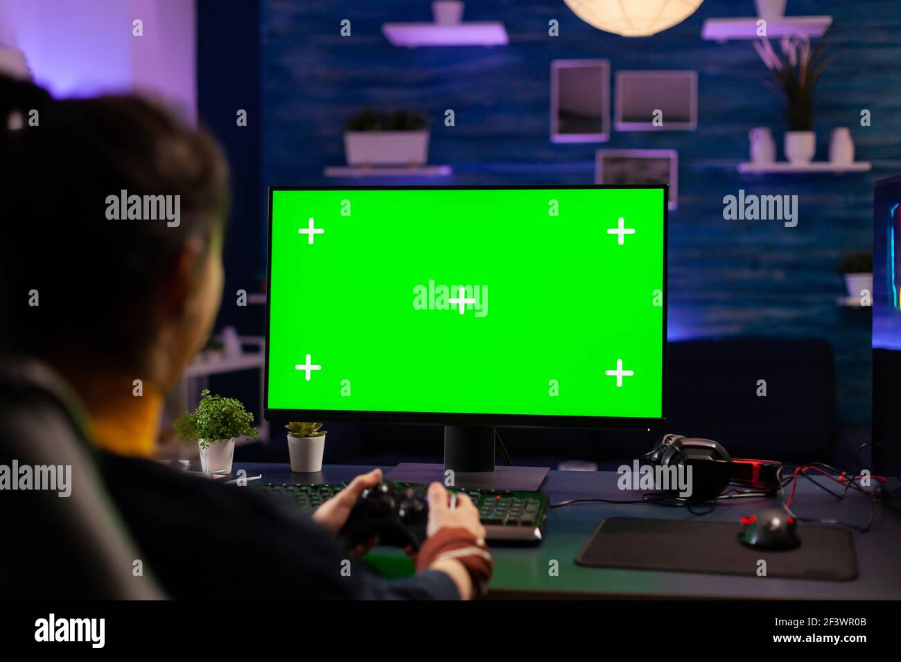 Pro gamer playing virtual videogames on professional powerful computer with green  screen display. Cyber Player using pc with mock up chroma isolated desktop  streaming shooter games wearing headset Stock Photo - Alamy