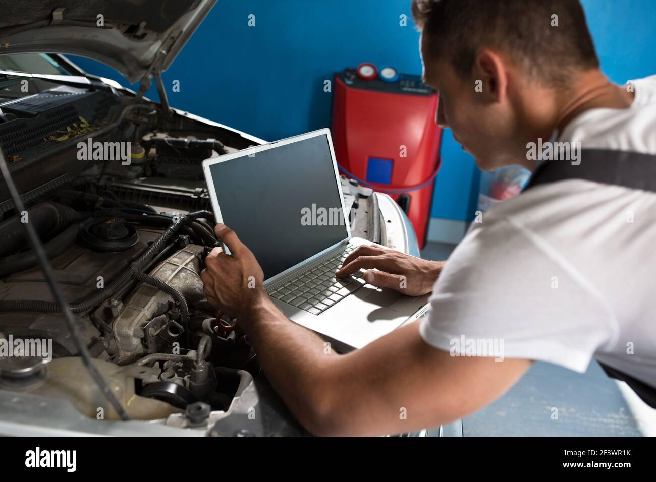 Mechanic with diagnostic tool in car checking problem Stock