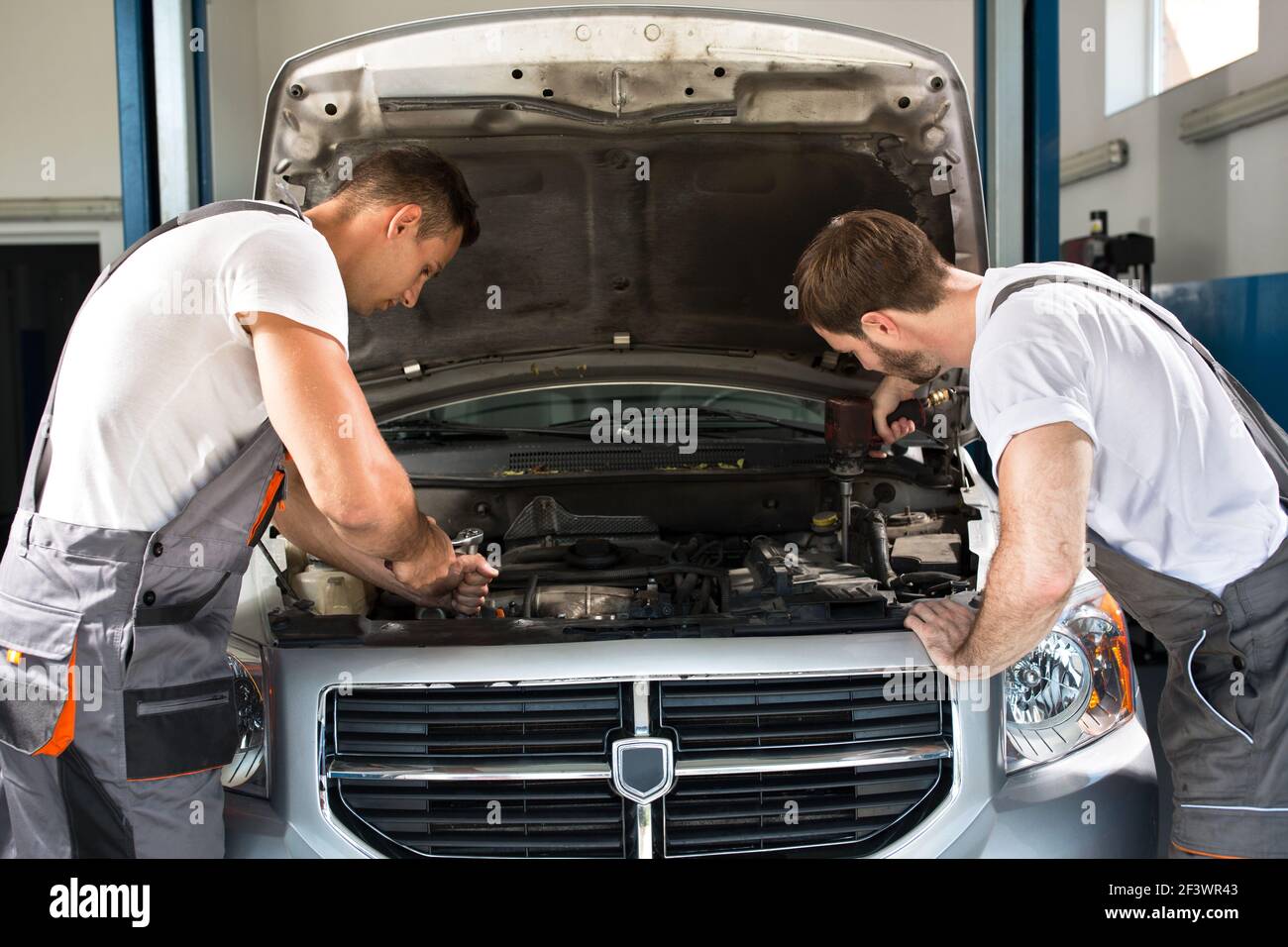 Team of mechanics working together in workshop Stock Photo