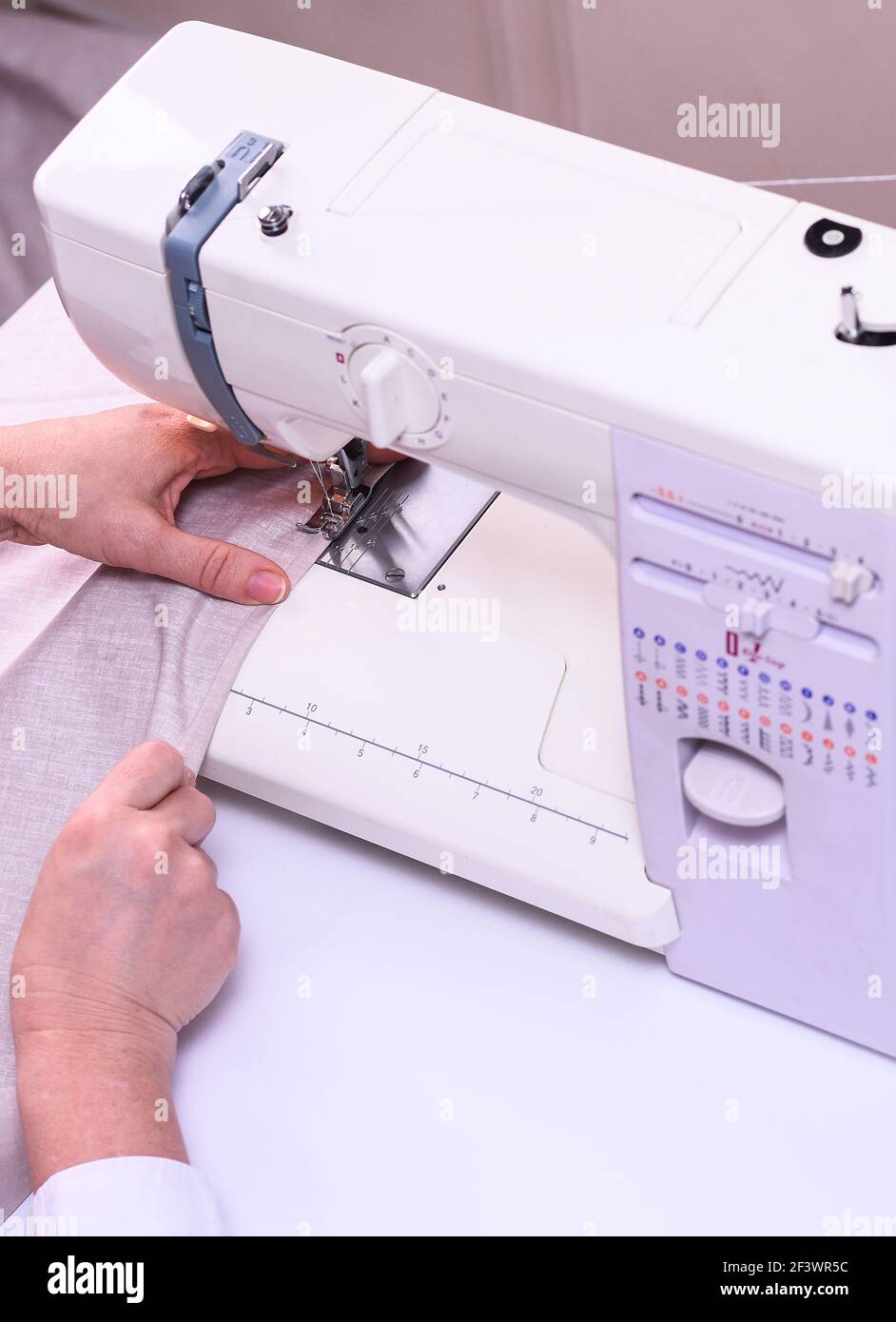 Female hands stitching light fabric on machine Stock Photo Alamy