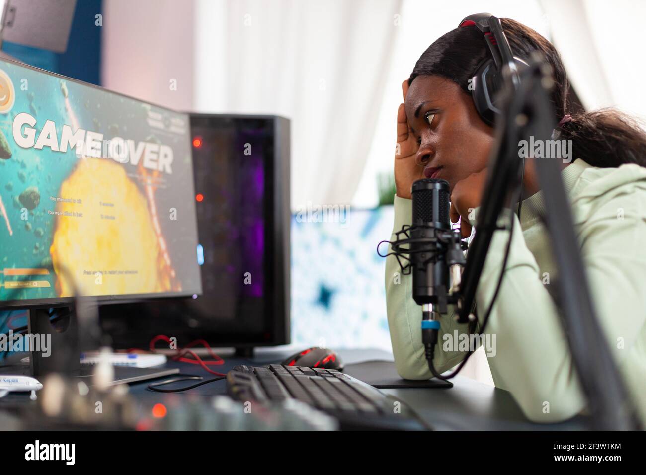 African esport streamer being upset losing video game championship. Professional gamer streaming online video games with new graphics on powerful computer. Stock Photo