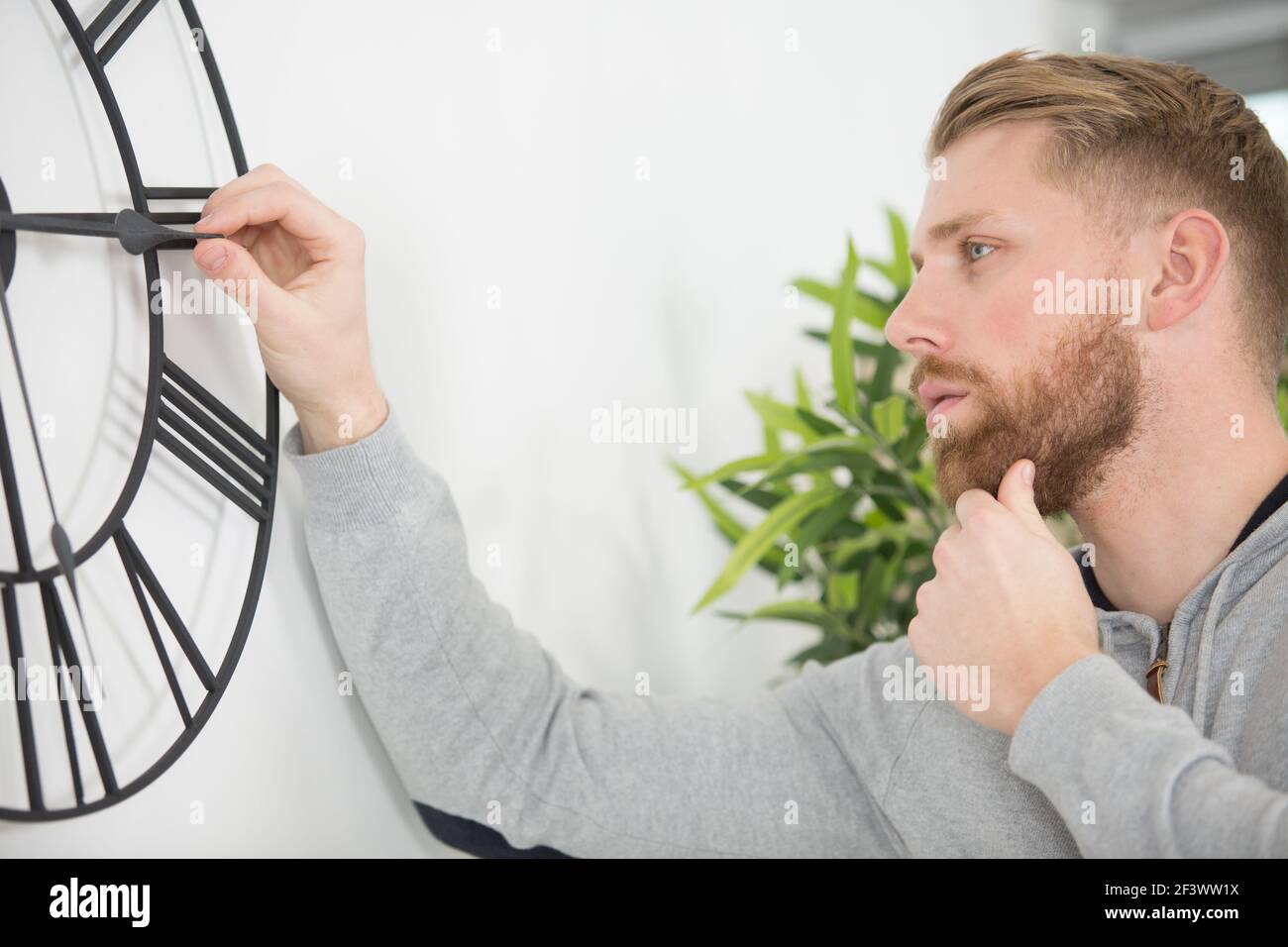 man changing the clock on the wall Stock Photo Alamy