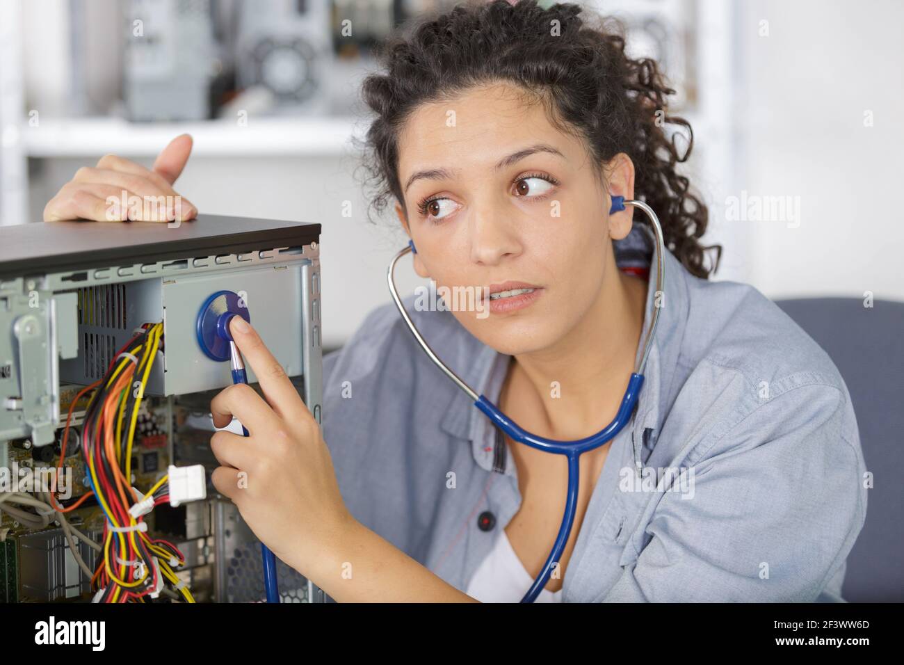 female technician using stethoscope for examines computer Stock Photo