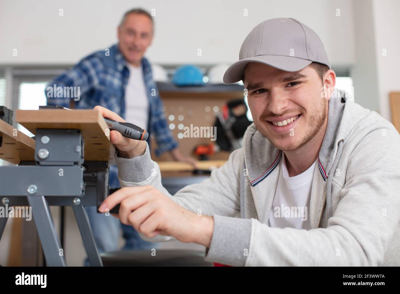 young worker is fixing a table Stock Photo - Alamy