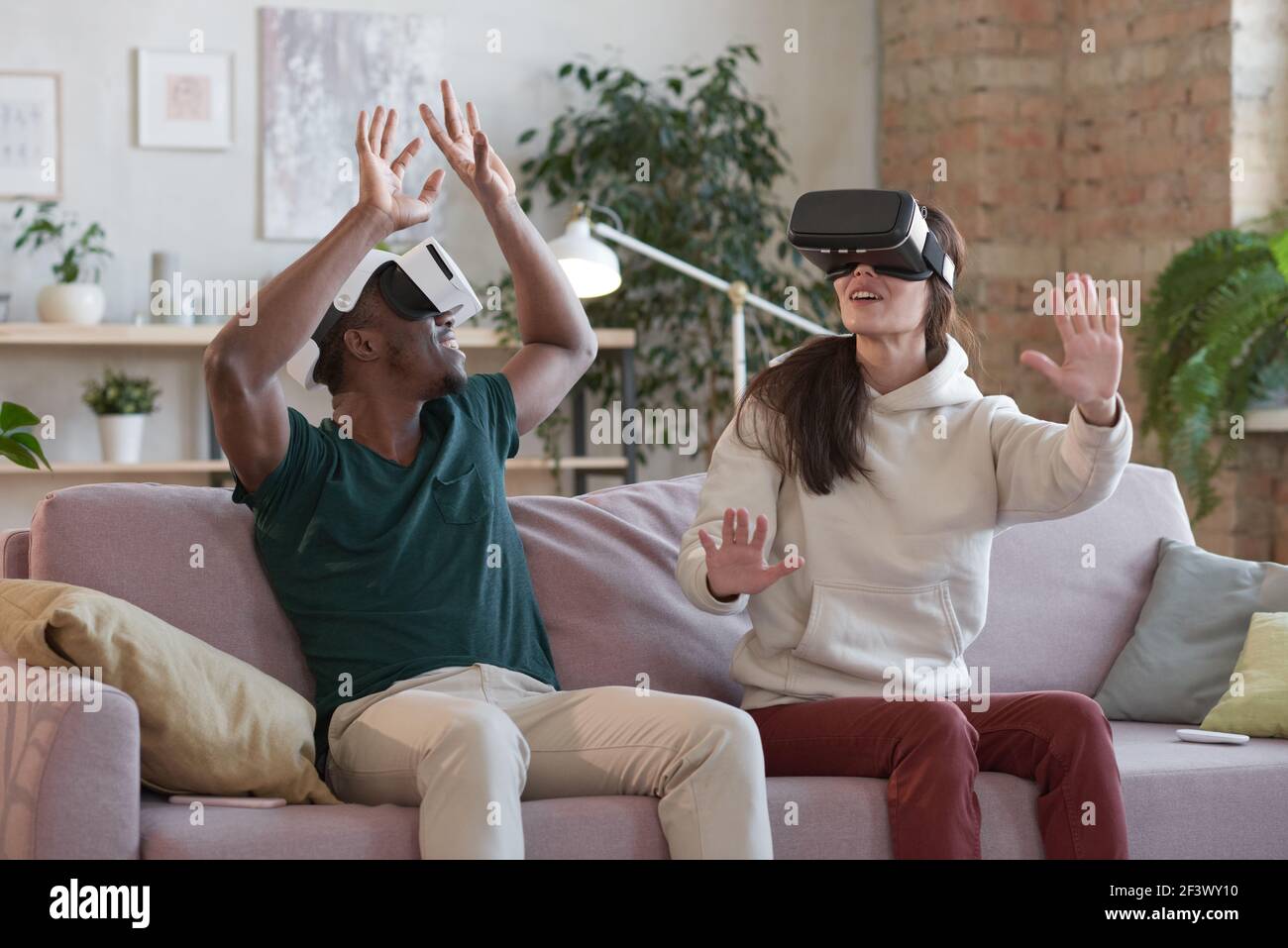 Young couple playing games with virtual reality headset Stock Photo