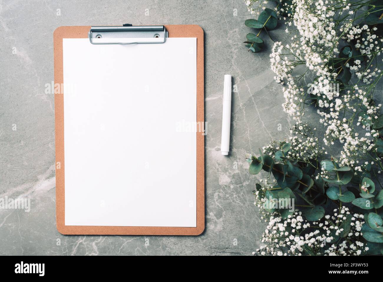 Feminine workspace with notebook clipboard paper pink peony