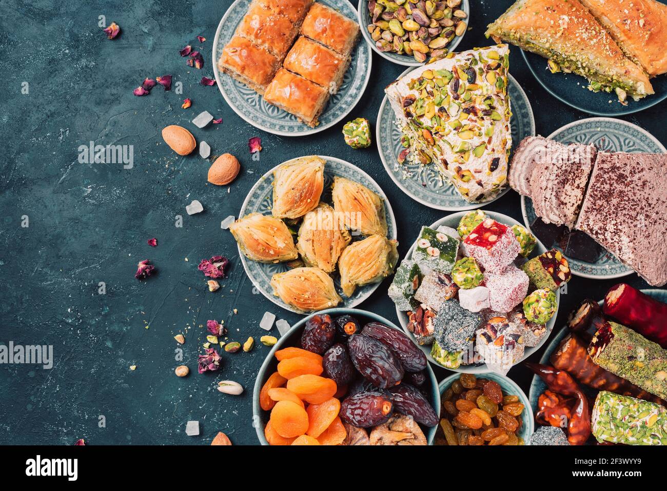 Middle Eastern sweets on dark background. Arab dessert, baklava, halva, rahat lokum, sherbet