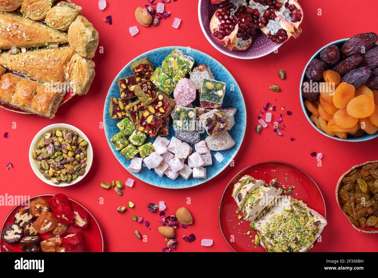 Middle Eastern sweets on red background. Arab dessert, baklava, halva
