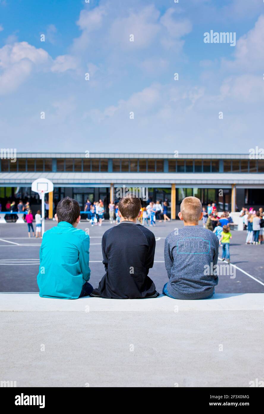 Atmosphere with pupils in the schoolyard of the “College Simone Veil” junior high school in Crevin (Brittany, north-western France). Three boys viewed Stock Photo