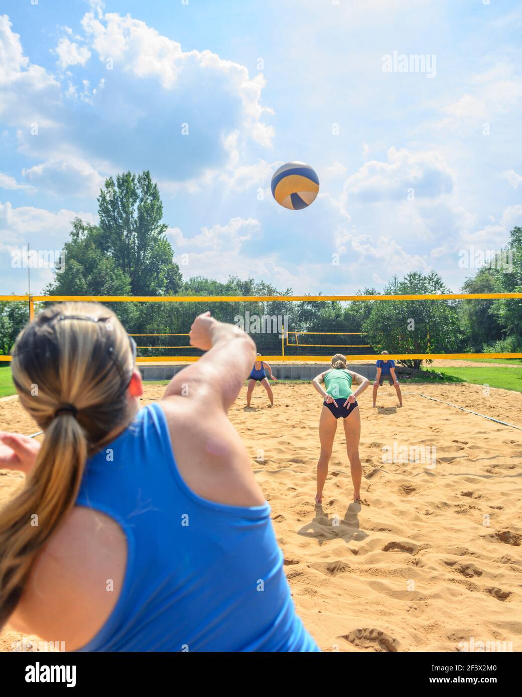 Trendy summer sport - young people playing Beachvolleyball Stock Photo