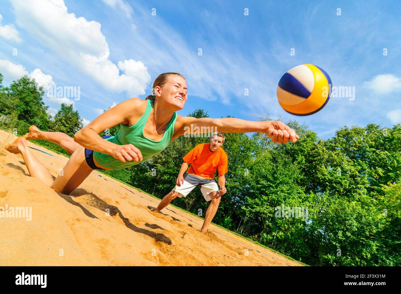 Trendy summer sport - young people playing Beachvolleyball Stock Photo