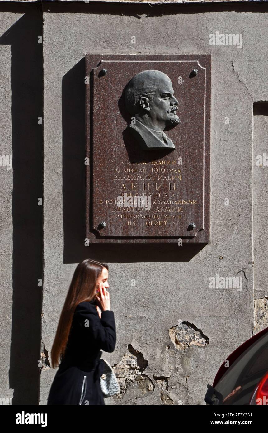 A woman talking on the phone walks past a plaque of Lenin, Moscow, Russia  Stock Photo - Alamy