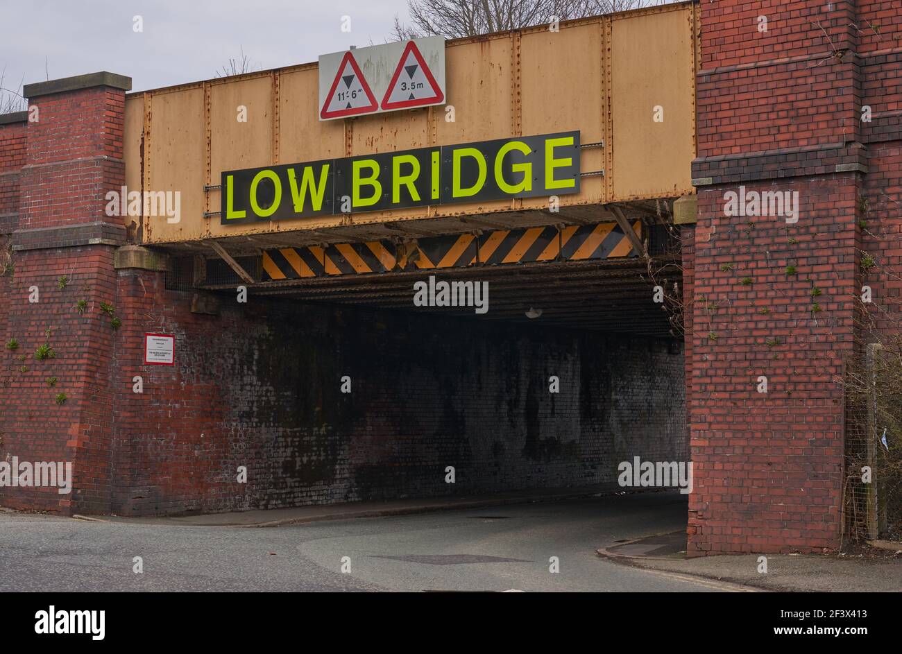 Low railway bridge over road in Manchester Stock Photo