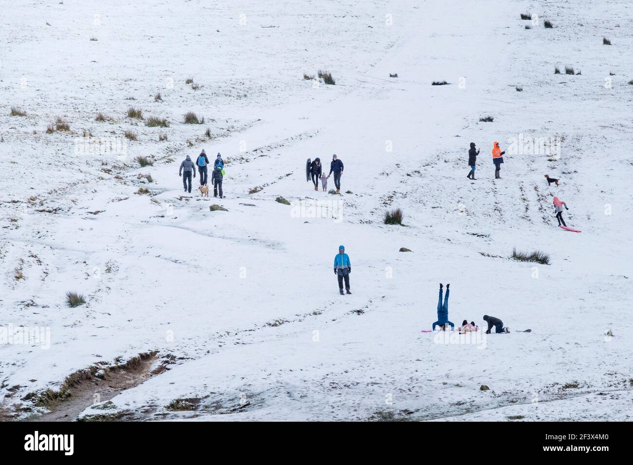 People enjoying a walk in the snow on Rough Tor on Bodmin Moor in Cornwall. Stock Photo