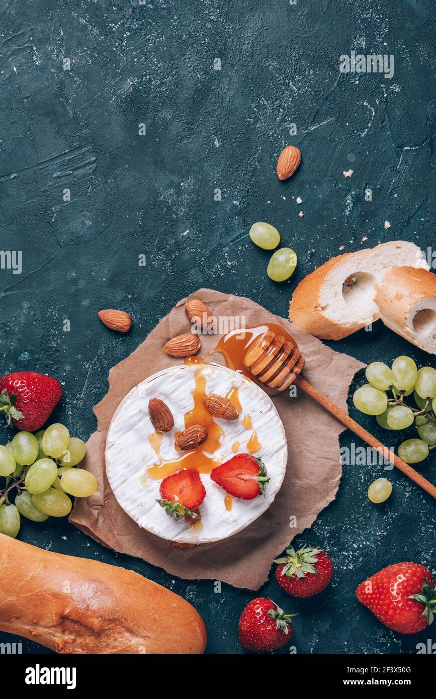 French camembert cheese served on grape, honey, almond, strawberries