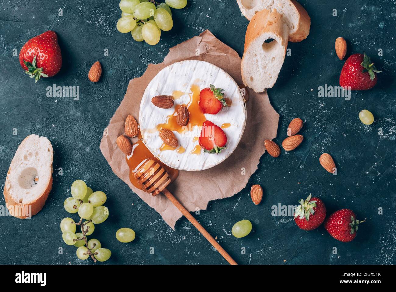 French camembert cheese served on grape, honey, almond, strawberries