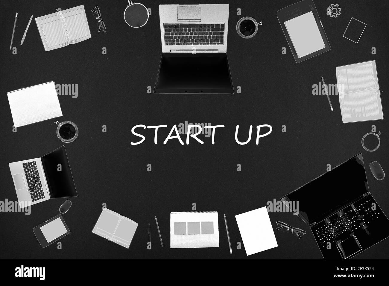 Start up concept. Top layout of drawings of laptops, notepads, coffee, different business stuff on black background. Stock Photo
