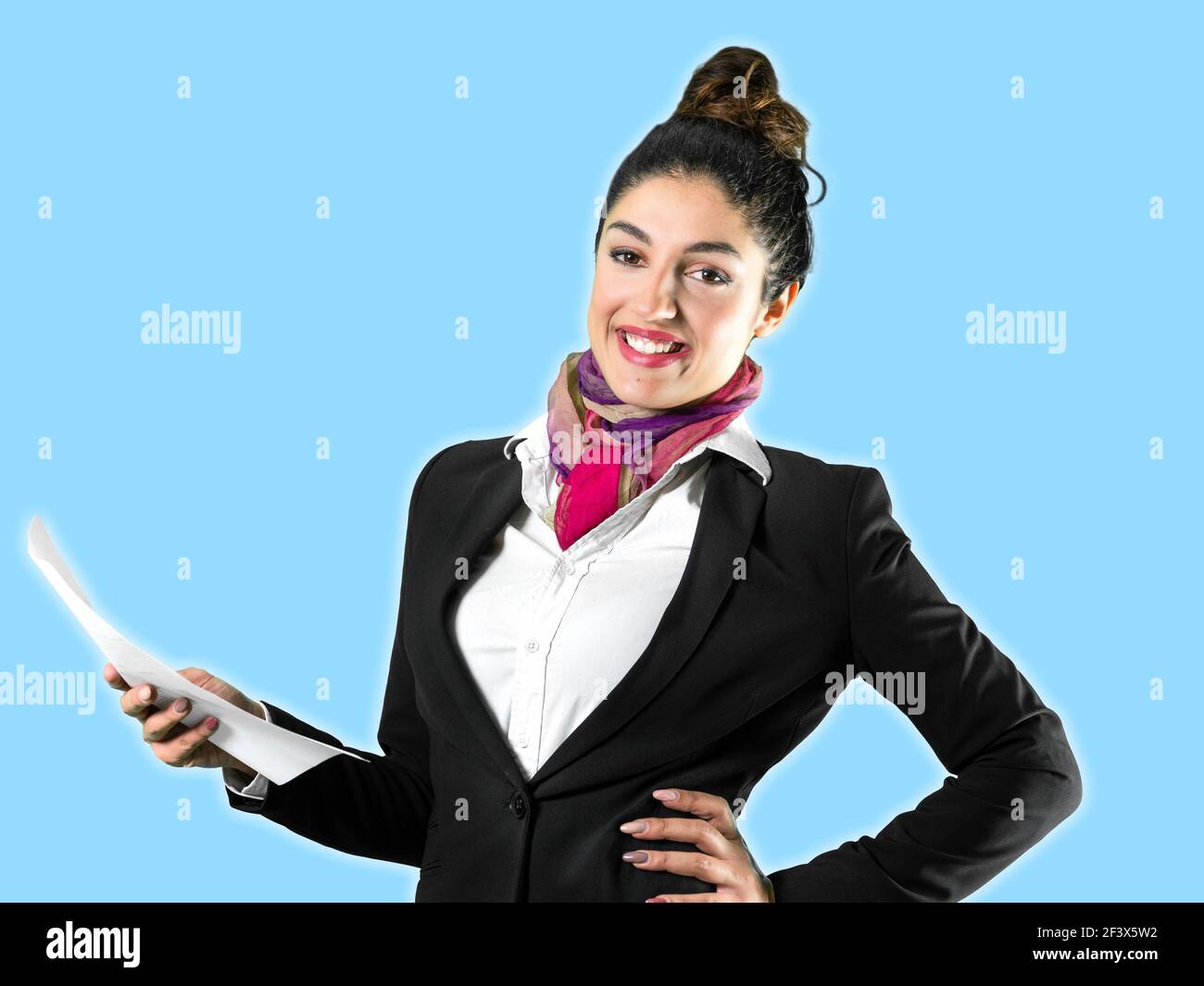 A beautiful flight attendant in a black jacket and mask in front of a solid background. Perfect shot for commercial, pandemic, virus, quarantine, wome Stock Photo