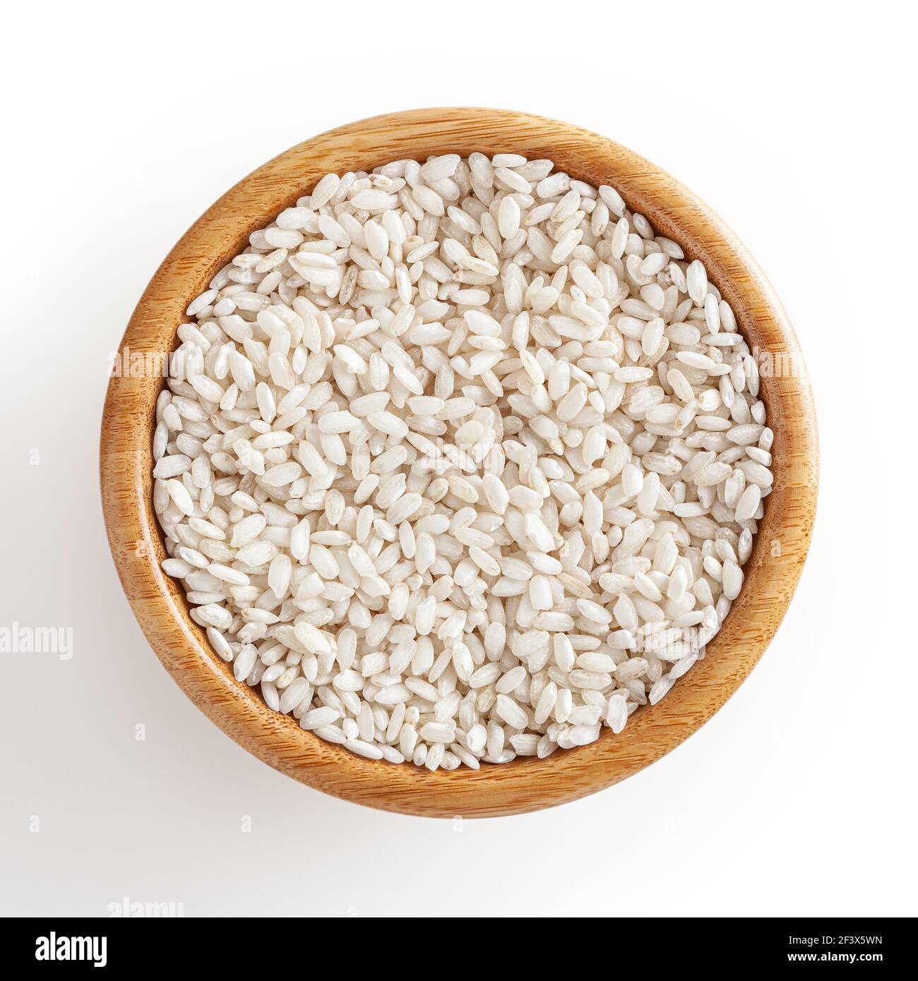 Uncooked arborio rice in wooden bowl isolated on white background with