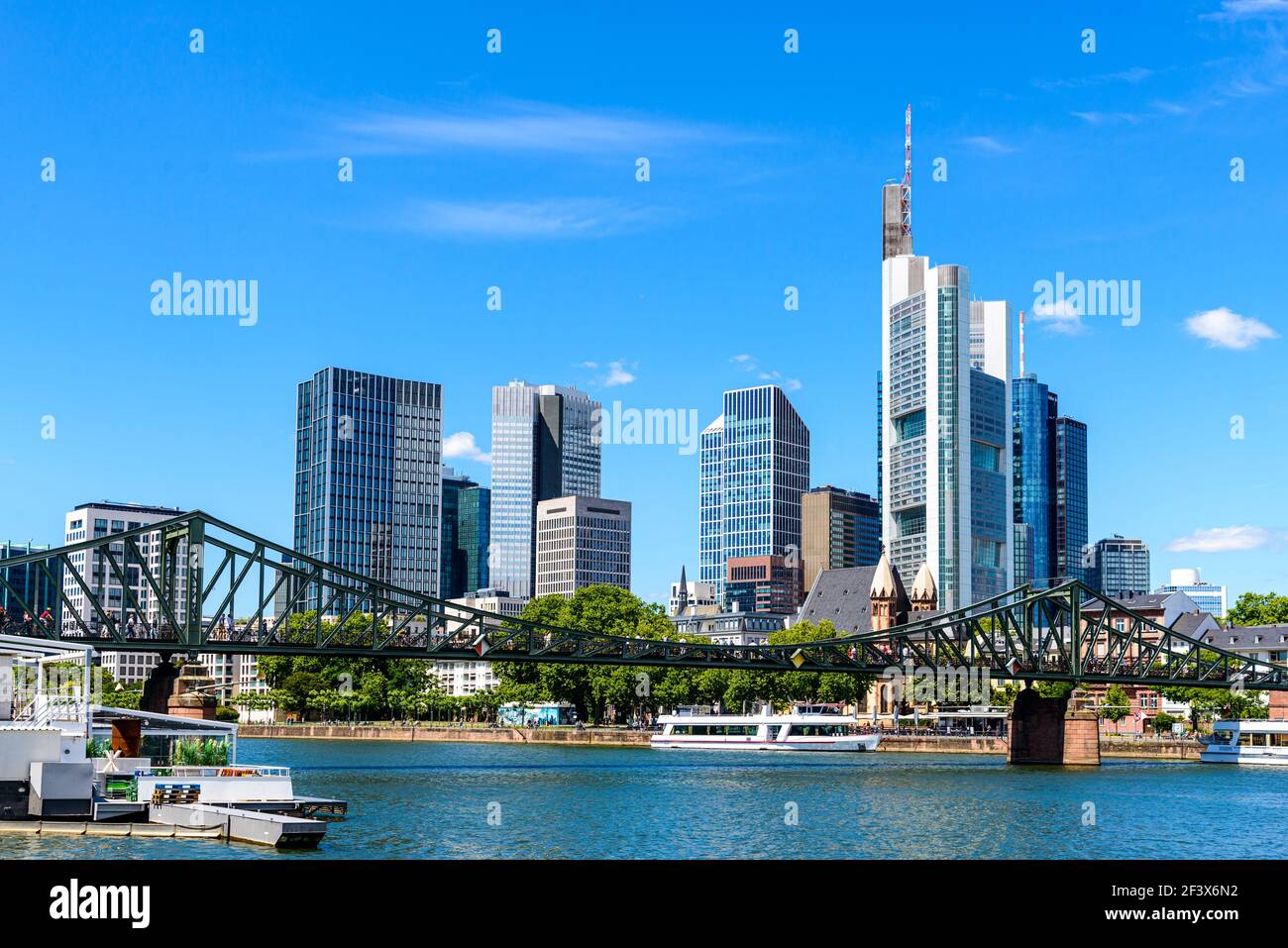Beautiful view on  Frankfurt am Main skyline cityscape with blue sky, clouds, Main river, bridge Eiserner Steg in spring. Hessen, Hesse, Germany Stock Photo
