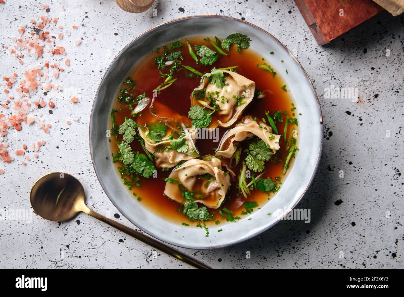 Asian meat stuffed dumplings with bouillon in bowl Stock Photo