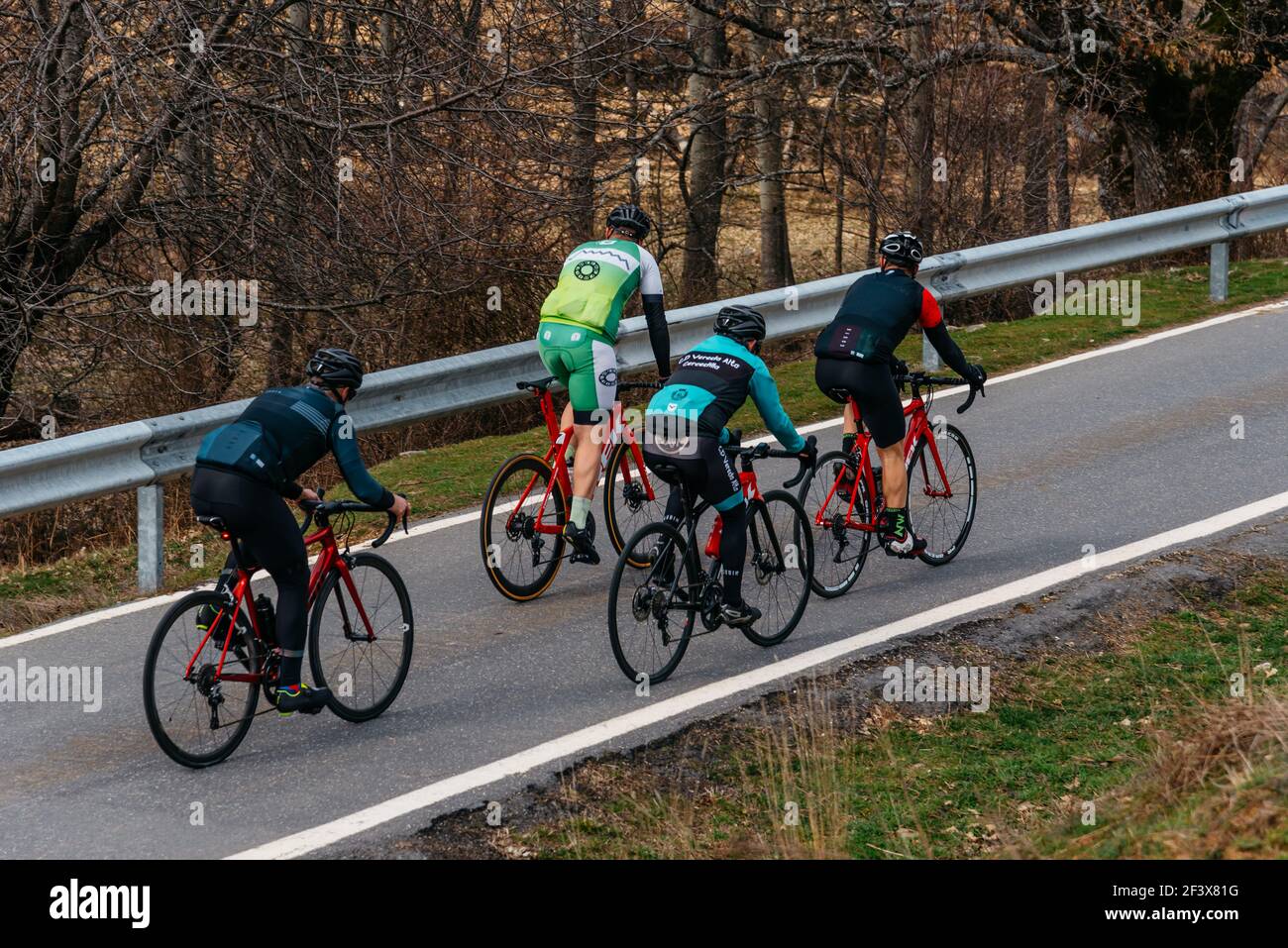 Puebla de la Sierra, Spain - February 28, 2021: Cyclists on Mountain Road. Riding and Having Fun on Empty Road Stock Photo