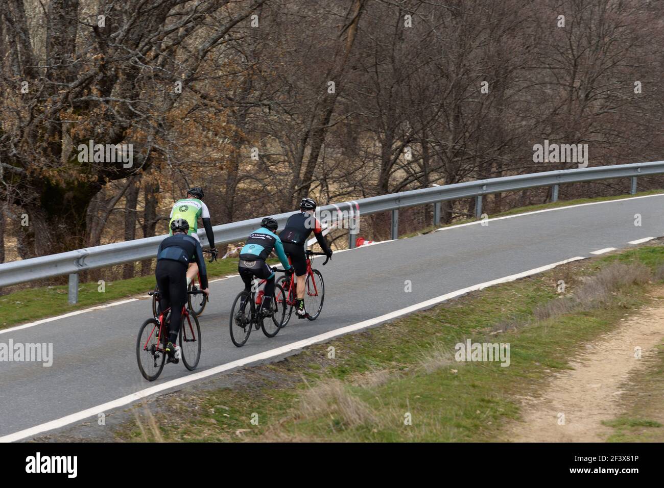 Puebla de la Sierra, Spain - February 28, 2021: Cyclists on Mountain Road. Riding and Having Fun on Empty Road Stock Photo