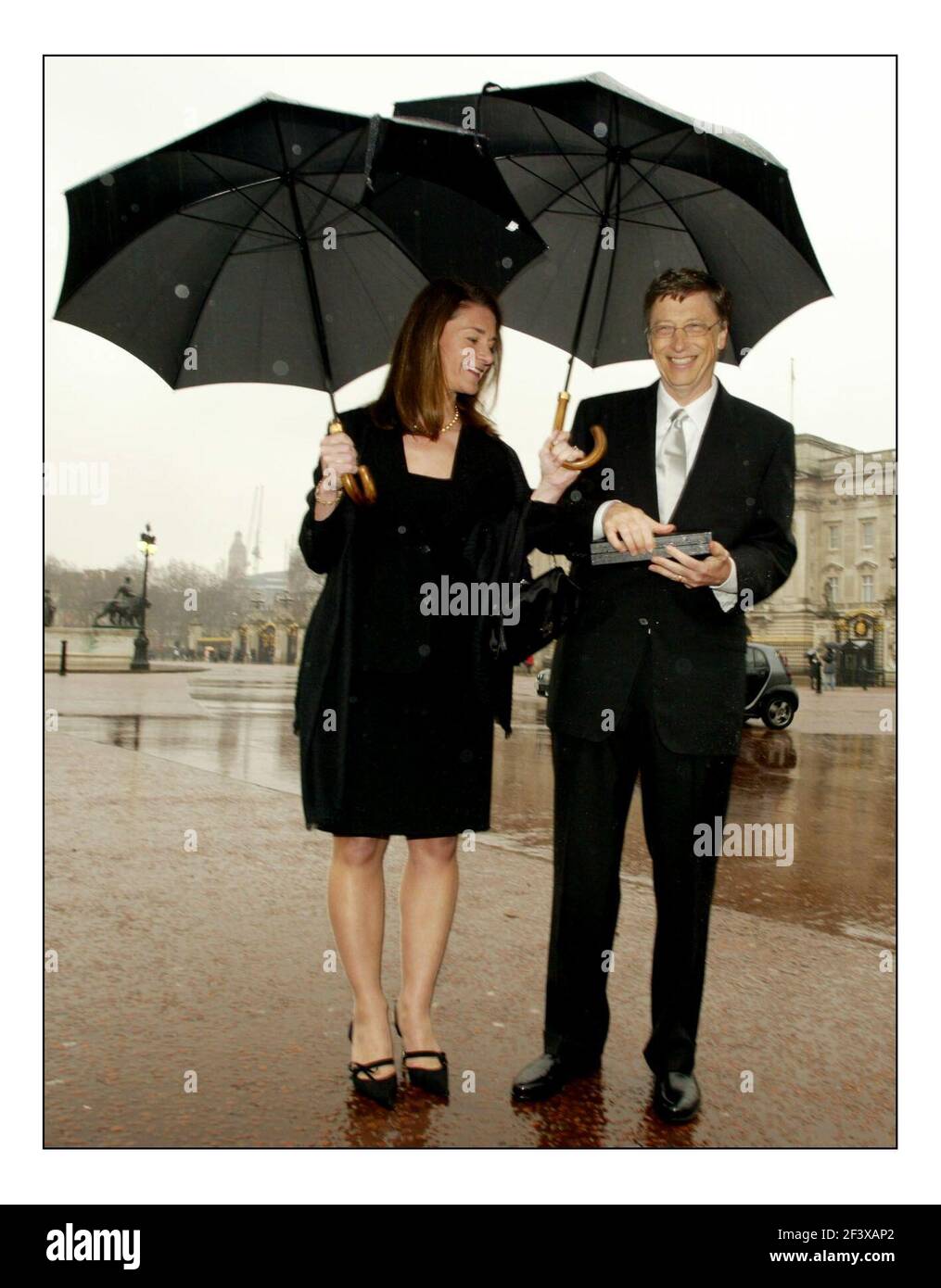 Bill Gates, co-founder of the Bill & Melinda Gates Foundation and chairman of Microsoft Corp. Poses with his wife Melinda outside Buckingham Palace after recieving his honarary knighthood from Queen Elizabeth today.pic David Sandison 2/3/2005 Stock Photo