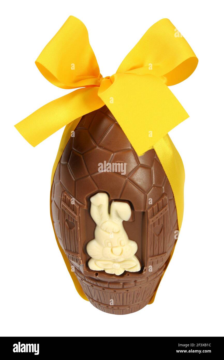 Easter celebration concept: big chocolate egg with yellow ribbon and Easter bunny, isolated on white background without shadows - Stock Image